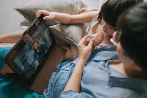 Parent and child talking to doctor over tablet 