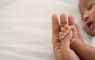 Newborn Baby Hand Holding Mom’s Finger