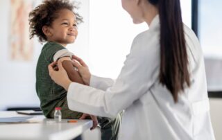 Young cheerful child receives vaccination