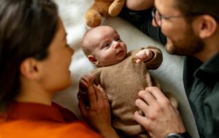 Parents smiling over newborn baby