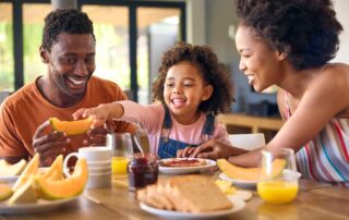 Family of three eating breakfast at table