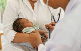 Newborn baby in parent’s arms during pediatric examination