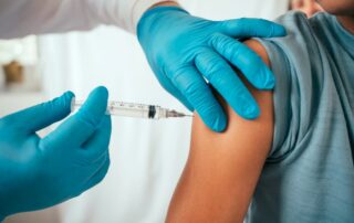 Pediatrician injecting a vaccine into a child’s arm