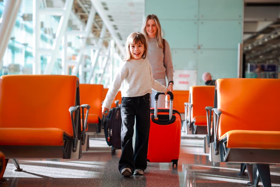 Parent with young child with suitcases at airport