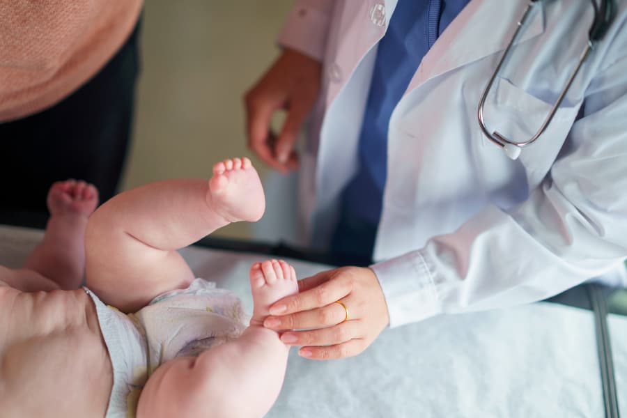 Pediatrician examining baby during routine check-up